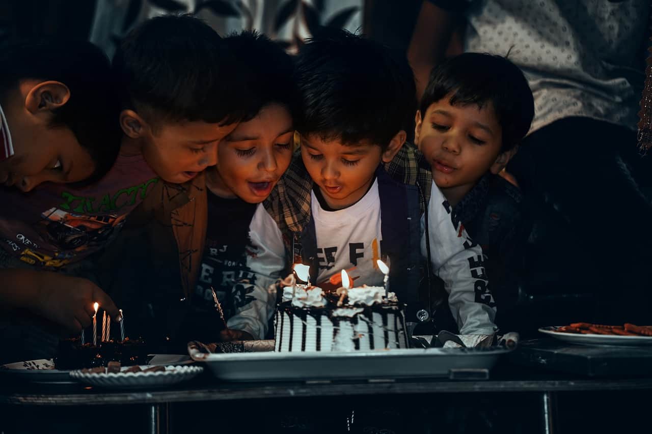לנשוף נר של עוגת יום הולדת לילד עם חברים